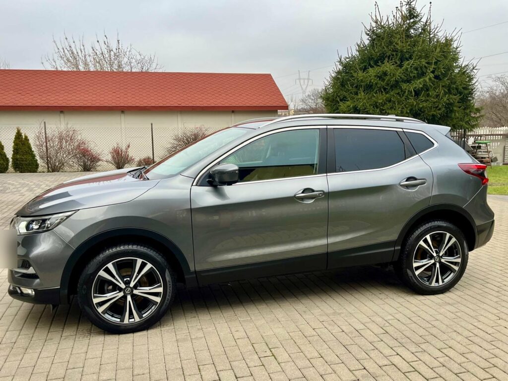 Grafitowy Nissan Qashqai widziany z boku, tablica rejestracyjna rozmyta